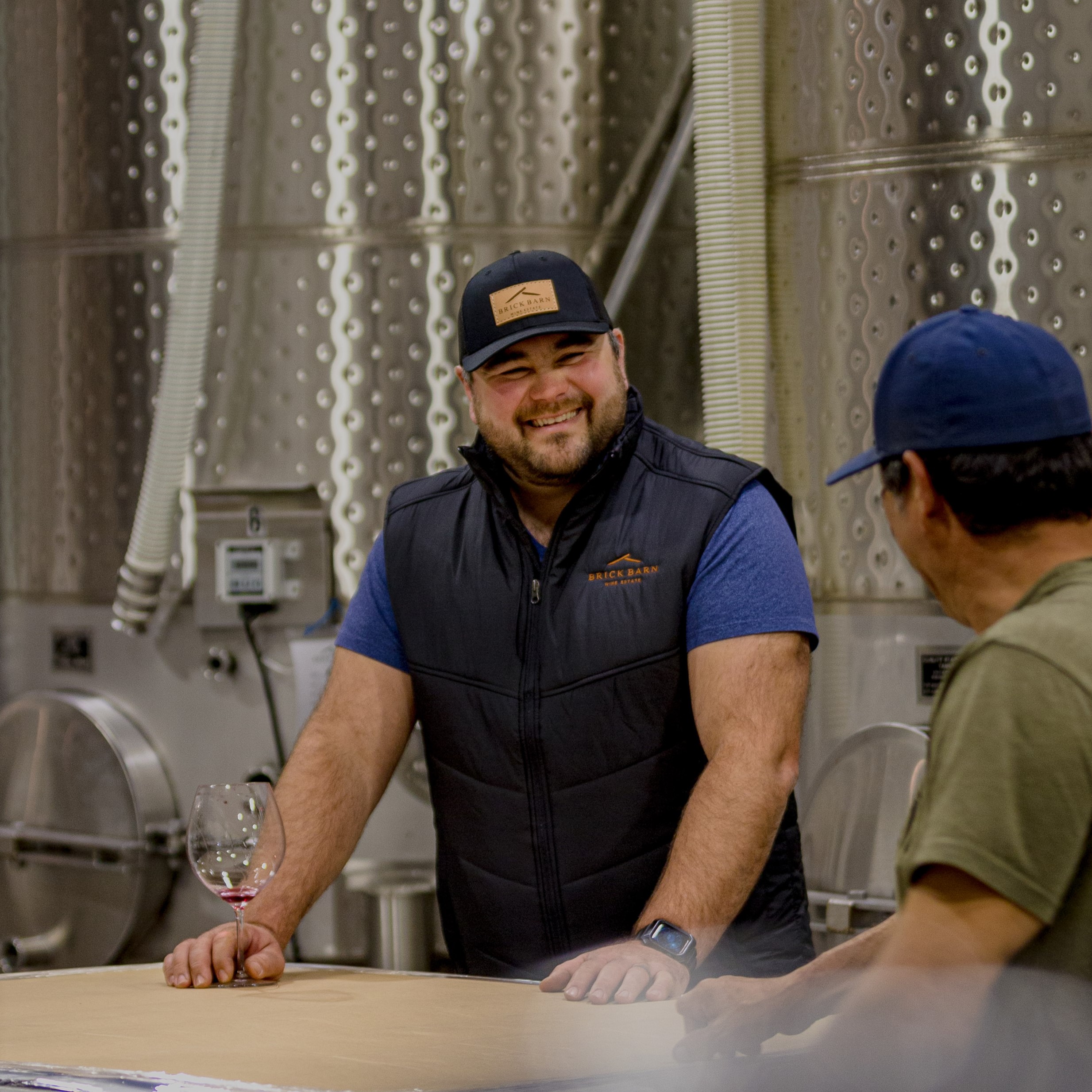Brick Barn wine maker Adrian Bolshoi laughing with a guest in the winery