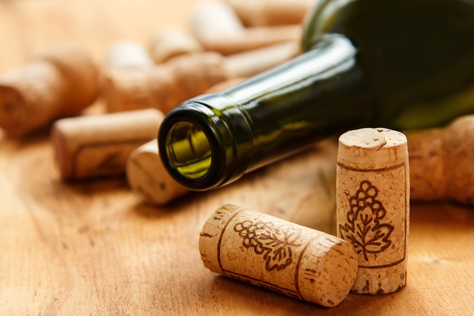 An open bottle of wine laying down surrounded by wine corks